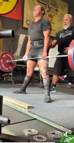 Narayana at lockout on a deadlift at a powerlifting meet